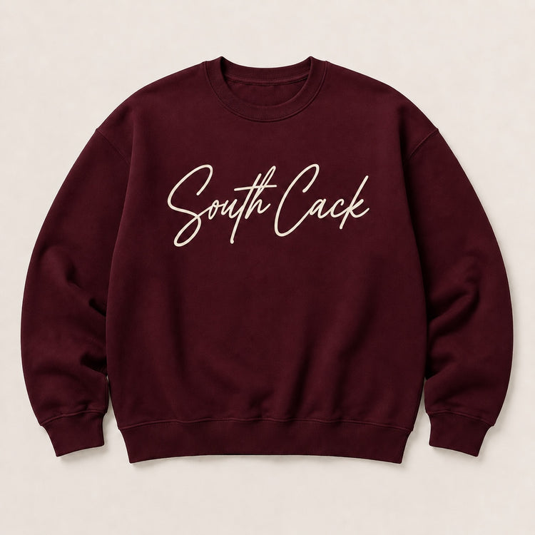 saysomethingteez maroon crewneck sweatshirt with white script South Cack graphic, featuring ribbed cuffs and hem.